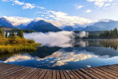 Güzel dağ gölü Strbske Pleso yansıması, dağlar, gökyüzü ve bulutlar sakin suda yüksek Tatras, Slovakya ile