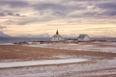 Güzel kış günbatımı manzarası, panoramik beyaz yalnız kilise ve ev Atlantik kıyısında, Lofoten Adaları, Norveç