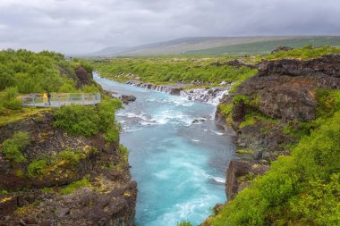 Hraunfossar şelaleler veya lav Şelaleleri, İzlanda. Güzel yaz manzara, lav kayaları zümrüt renkli Hvita nehire yoluyla su akıyor. İzlanda'daki en sıradışı şelaleler biri