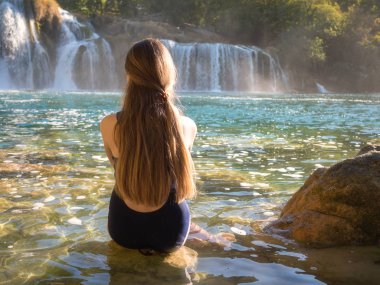 Krka Milli Parkı'nda, ünlü Skradinski buk, bir Avrupa'nın en güzel şelaleler ve Hırvatistan'daki en büyük şelale manzarayı uzun saçlı güzel genç kız