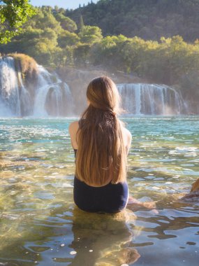 Krka Milli Parkı'nda, ünlü Skradinski buk, bir Avrupa'nın en güzel şelaleler ve Hırvatistan'daki en büyük şelale manzarayı uzun saçlı güzel genç kız