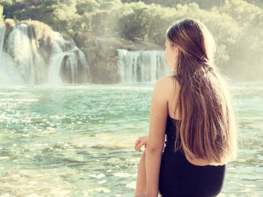 Krka Milli Parkı'nda, ünlü Skradinski buk, bir Avrupa'nın en güzel şelaleler ve Hırvatistan'daki en büyük şelale manzarayı uzun saçlı güzel genç kız