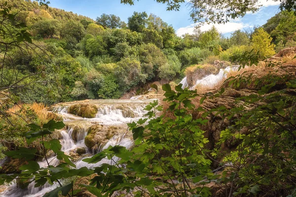 Nature daytime landscape - waterfall cascades surrounded by green forest, Krka National Park, famous tourist destination in Croatia