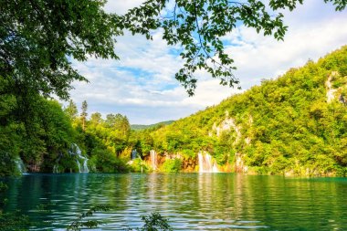 Plitvice Gölleri Milli Parkı güzel gündüz peyzaj, yeşil orman, şelaleler, mavi bulutlu gökyüzü ve şaşırtıcı yeşil su yansıma Doğa Göl, resim duvar kağıdı ya da rehber kitap için uygun