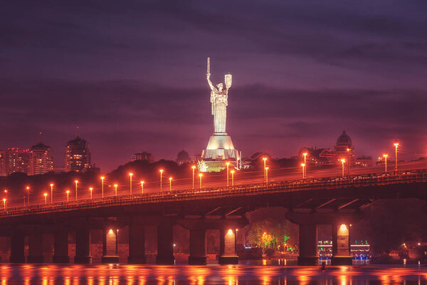 Kiev, Ukraine - May 04, 2018: View of the Paton bridge, Motherland monument and Dnieper river at night, beautiful cityscape with city lights, Kyiv the capital of Ukraine