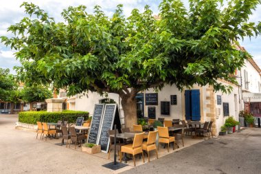 Saintes-Maries-de-la-Mer, Fransa-19 Temmuz 2017: turizm restoran büyük yeşil ağaç, Camargue, Provence, Fransa altında ile şehir içinde