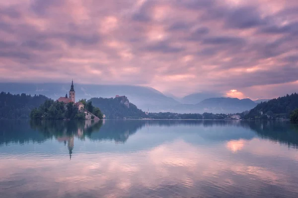 神秘的粉红色日落在高山湖布莱德 阿尔卑斯山和中世纪圣母升天玛丽朝圣教会在海岛与反射在水 — 图库照片