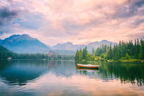 Güzel dağ gölü tekne ve yeşil çam ile rocky Dağları ile çevrili ağaçlar, popüler turizm, göl Strbske pleso, Yüksek Tatras, Slovakya (Slovensko)