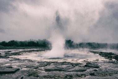 Muhteşem Strokkur gayzer su, popüler turistik, Haukadalur Jeotermal alanı, İzlanda dramatik vintage görüntüsü Çeşmesi sürer