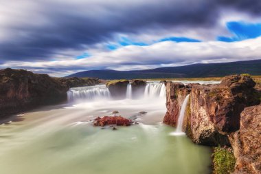 Godafoss (Akureyri) şelale güneşli gün, ikonik İzlanda'nın muhteşem manzara mavi gökyüzü bulutlu, uzun pozlama yerleştirin. Skjalfandafljot Nehri, Norurland, Kuzey İzlanda