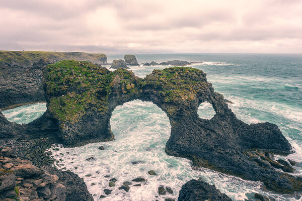Amazing seascape, Gatklettur basalt rock arch at the volcanic cliff, Atlantic coast of Arnarstapi in the west of Iceland, natural travel background. Arnarstapi, Snaefellsnes peninsula, Iceland, Europe
