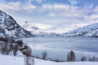 Güzel kış gündüz Gölü, karlı dağlar ile manzara ve bulutlu gökyüzü, Lofoten Adaları, Norveç mavi