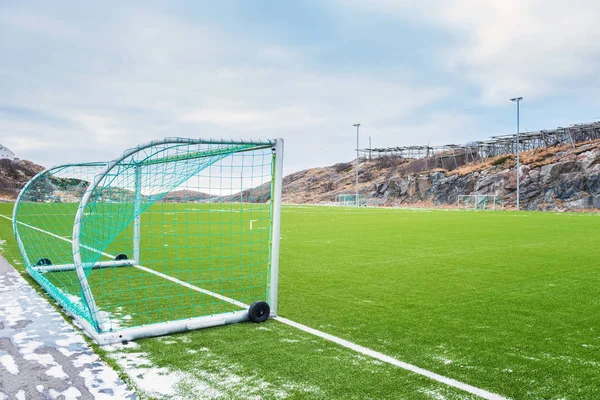 Football goal on the football field on Lofoten Islands surrounded by rocks and stones. Sport in Norway, Henningsvaer, Nordland