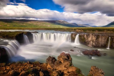 Godafoss (Akureyri) şelale güneşli gün, ikonik İzlanda'nın muhteşem manzara mavi gökyüzü bulutlu, uzun pozlama yerleştirin. Skjalfandafljot Nehri, Norurland, Kuzey İzlanda