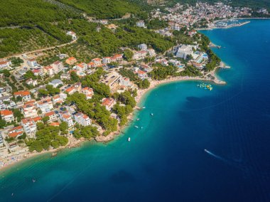 Hırvatistan, Dalmaçya 'daki Makarska Riviera' nın muhteşem hava manzarası. Adriyatik deniz kıyısındaki popüler turizm beldelerinin gündüz manzarası kayalık Dinara dağlarının eteklerinde, dış seyahat arka planında