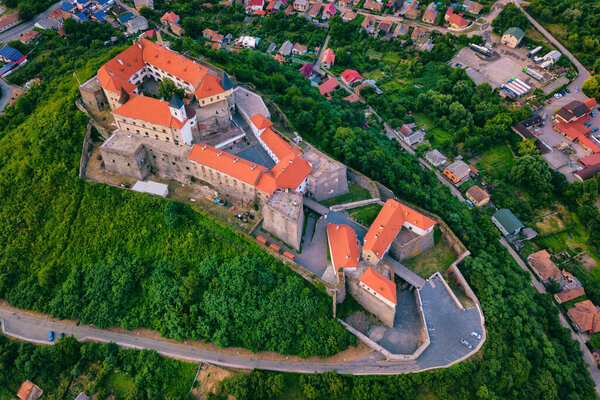 Aerial view of medieval castle Palanok, Mukachevo (Munkacs), Transcarpathia (Zakarpattia), Ukraine. Summer landscape with old architecture, green trees and town, outdoor travel background