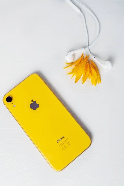 12.08.2019 Ucrania: iPhone xr amarillo y auriculares sobre fondo aislado —  Fotos de Stock