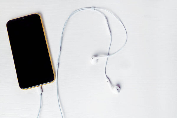 12.08.2019 Ukraine: yellow iphone xr and headphone on isolated background