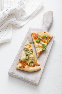 Peynirli pizza beyaz kesme tahtası üzerinde iki adet