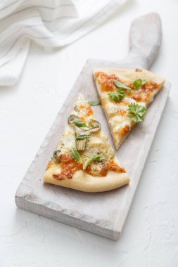 Peynirli pizza beyaz kesme tahtası üzerinde iki adet