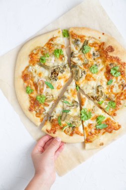 Çocuğu almak parça pizza ile articholke, üstten görünüm