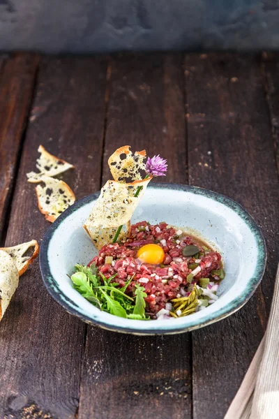 Delicioso filete tartar con yema, alcaparras, cebolla verde y pan — Foto de Stock