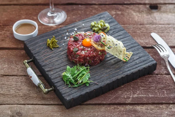 Filete tartar servido con alcaparras, pepinos en escabeche y cebolla picada . — Foto de Stock