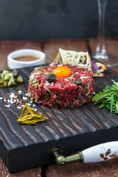 Delicioso filete tartar con yema, alcaparras, cebolla verde y pan — Foto de Stock