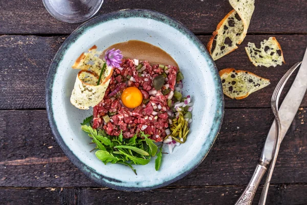 Delicioso filete tartar con yema, alcaparras, cebolla verde y pan — Foto de Stock