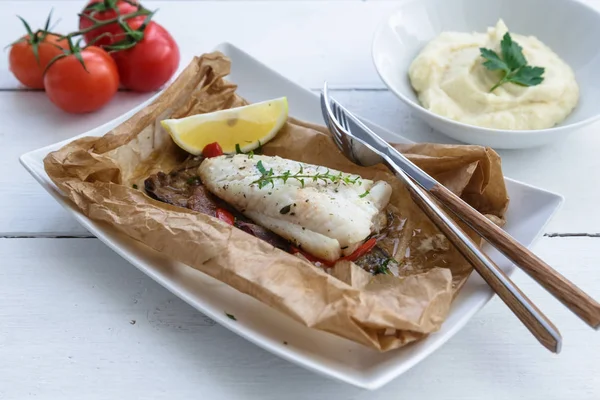 Filetes de bacalhau assados em pergaminho com legumes — Fotografia de Stock