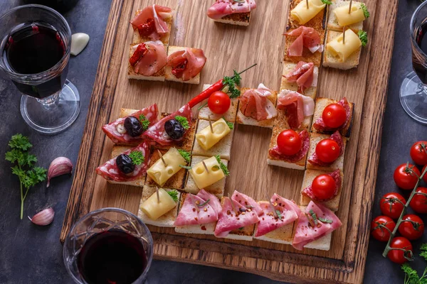 Vista da vicino di piccole tapas spagnole con marmellata, salsiccia, formaggio e vino — Foto Stock