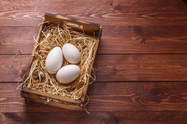 Τρία μεγάλα φρέσκα αυγά χήνας σε φωλιά από σανό σε ένα κουτί, copyspace — Φωτογραφία Αρχείου