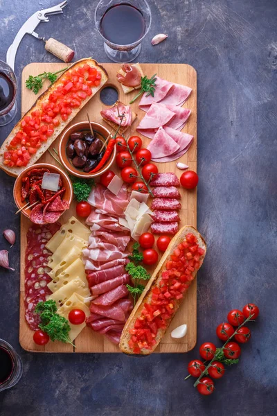 Σαλάμι, κομμένο σε φέτες ζαμπόν, προσούτο, τυρί, λουκάνικο, ντομάτα. Κρέας ορεκτικό σκάφους στο πέτρινο τραπέζι. Το Top view με αντίγραφο χώρου. — Φωτογραφία Αρχείου