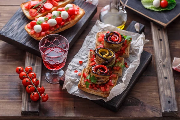 Bruschetta with tomato, basil and mozzarella cheese on wooden board. Traditional italian appetizer or snack, antipasto — Stock Photo, Image