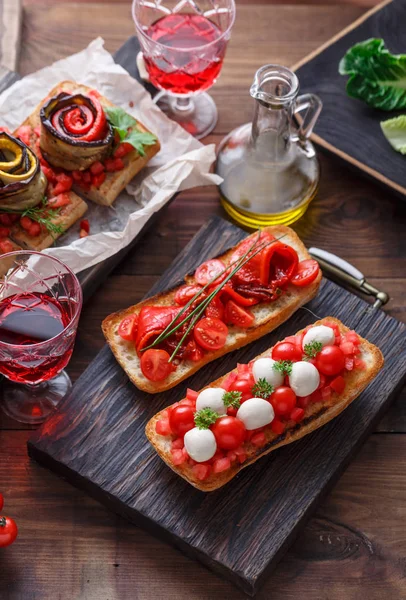 Bruschetta with tomato, basil and mozzarella cheese on wooden board. Traditional italian appetizer or snack, antipasto — Stock Photo, Image