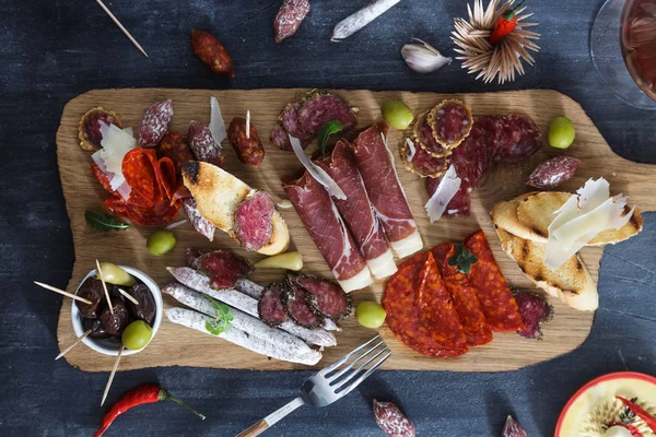 Conceito típico de tapas espanholas. incluem fatias variedade jamon, chouriço, salame, tigelas com azeitonas, pimentas. Espaço de cópia . — Fotografia de Stock