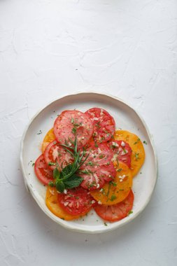 Domates bir tabağa dilimlenmiş. Üstten görünüm