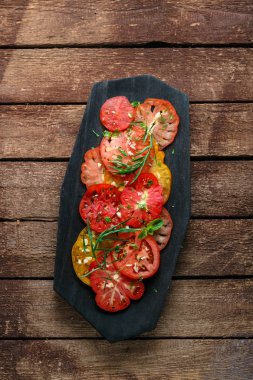 Domates bir tabağa dilimlenmiş. Üstten görünüm