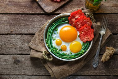 Domates ve yeşil fasulye, kopya alanı ile bakır tavada yumurta güneşli tarafı kızarmış.