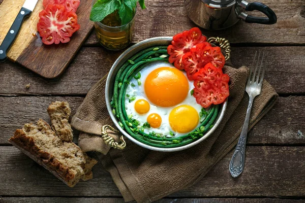 Huevos fritos de lado soleado en una sartén de cobre con tomates y judías verdes, espacio para copiar . —  Fotos de Stock