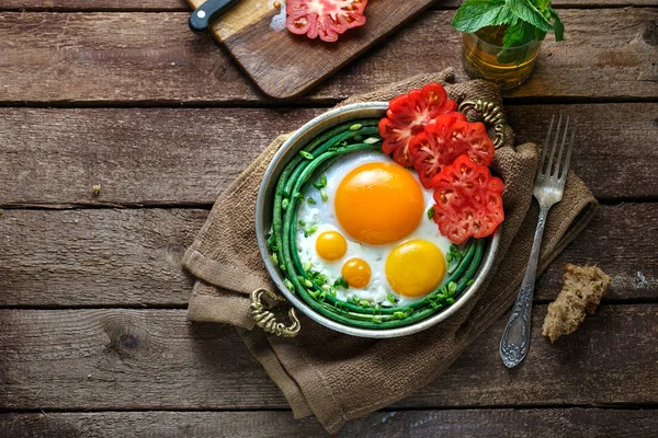 Huevos fritos de lado soleado en una sartén de cobre con tomates y judías verdes, espacio para copiar . —  Fotos de Stock