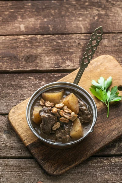 Gedeelte van massaman curry in koperen pan, bovenaanzicht, rustieke stijl — Stockfoto