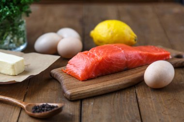 Otlar, tuz ve baharat ile ahşap tahta üzerinde Çiğ somon parçaları