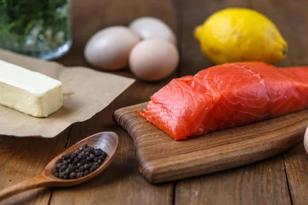 Pedaços de salmão crus em tábua de madeira com ervas, sal e especiarias — Fotografia de Stock