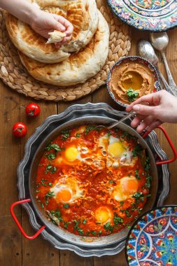 Ailece kahvaltı shakshuka, humus ve ekmek. üstten görünüm
