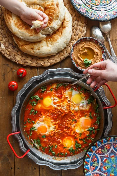 Desayuno familiar con shakshuka, hummus y pan. vista superior —  Fotos de Stock