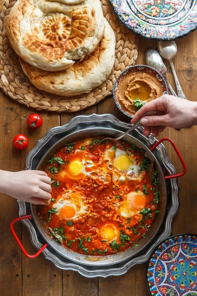 Ailece kahvaltı shakshuka, humus ve ekmek. üstten görünüm