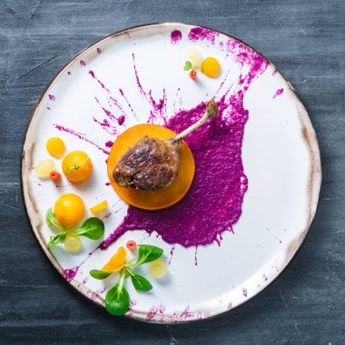 Ördek bacak confit lahana püresi ve beyaz tabakta restsurant yemek persimon