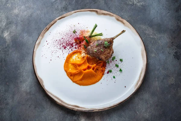 Duck leg confit with batat puree, carrots and couscous, restaurant meal — Stock Photo, Image