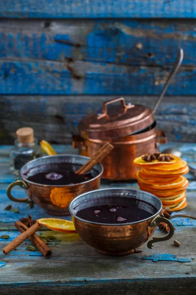 Vin chaud dans des tasses en cuivre avec des épices et des agrumes, espace de copie — Photo